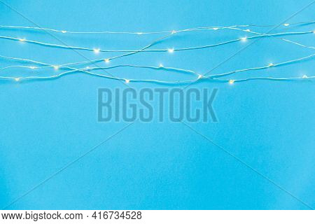 Blue Background With Lit Led Garland Lights. Top View