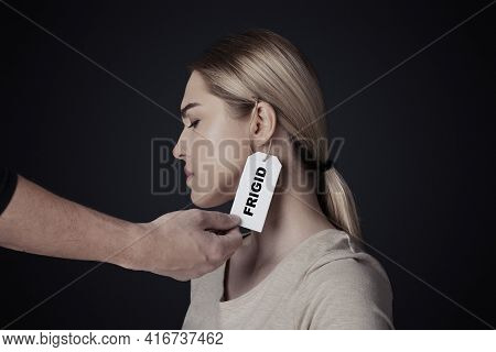 Physiology, Mental Problems, Sexism And Humiliation. Male Hand Hangs Label With Inscription Frigid O
