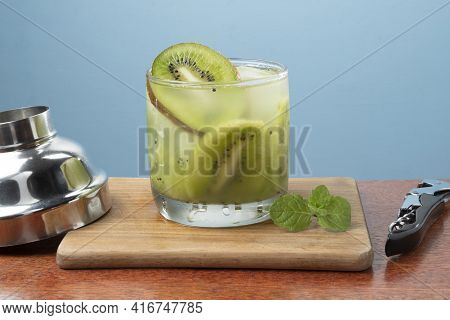 Alcoholic Drink Caipirinha Based On Kiwi And Aguardente Distilled Cocktail Drink And Fruits On Blue 