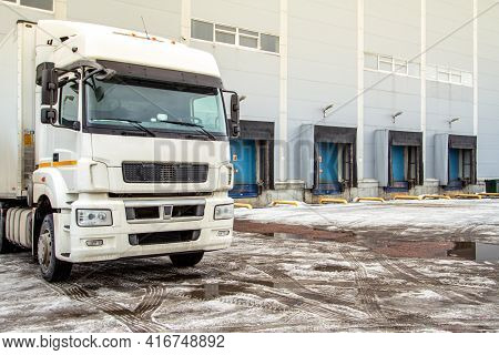 Truck While Loading In A Big Distribution Warehouse With Gates For For Loading Goods And Trucks