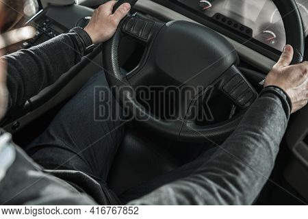 Caucasian Driver Behind Large Coach Bus Steering Wheel Top View. Commercial Public Transportation.