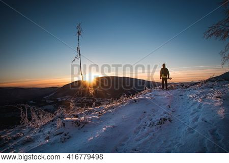 Sunrise In Winter In The Beskydy Mountains In Eastern Bohemia. A Teenager In A Colorful Jacket Stand