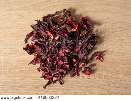 Dry Red Flowers Hibiscus On A Wooden Table
