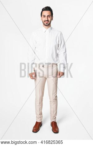 Man in white shirt and beige slacks full body