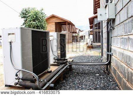 Air Conditioning Compressor On Brick Wall. Condensing