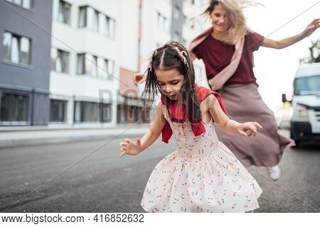 Horizontal Outdoor Image Of A Happy Little Girl Playing Hopscotch With Her Mother On Playground Outd