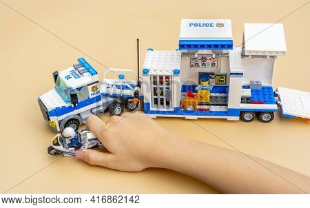 Cagnes-sur-mer, France - April 12, 2021: Boy Playing With Lego Mobile Police Truck. Toys From Bricks