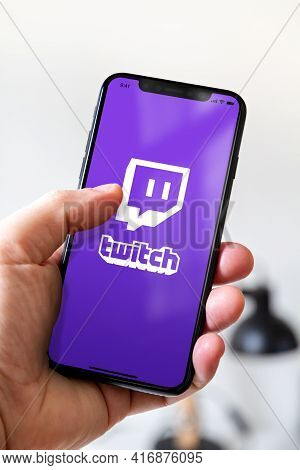 Paris - France - March 23, 2021 : Hand Holding Iphone Smartphone With Twitch Logo