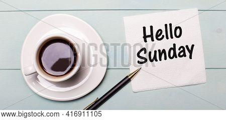 On A Light Blue Wooden Tray, There Is A White Cup Of Coffee, A Handle And A Napkin That Says Hello S