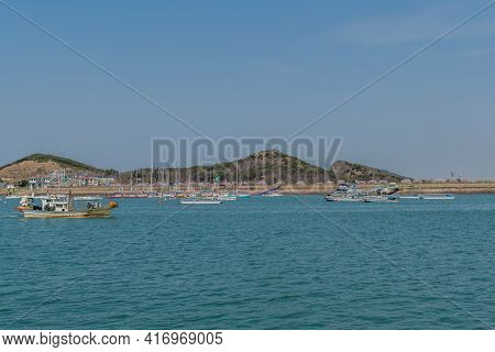Pyeongtaek, South Korea; April 6, 2021: Fishing Trawlers Sailing Across Harbor With Private Yachts A