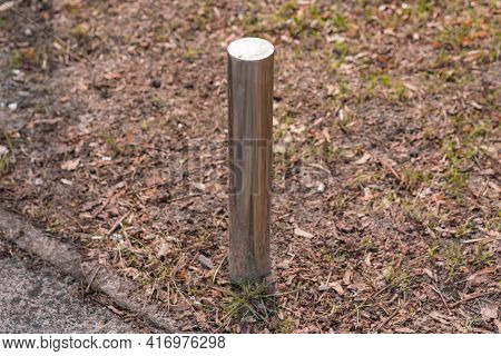 Pole Barrier On Sidewalk Installed On The Ground To Prevent Drive In The Park. Bollard. Nature. Prot
