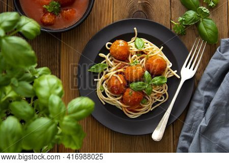 Spaghetti With Eatballs Tomato Sauce , Basil Leaves In Black Mate Plate On Wooden Background, Delici