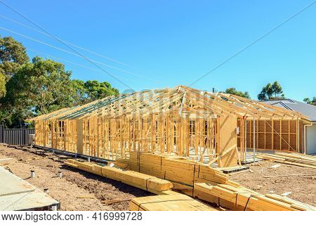 New Australian House Timber Frame Installation Process At Construction Site On A Bright Summer Day
