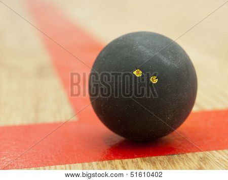 Black squash ball on t-line
