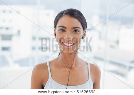 Cheerful pretty model listening to music in bright room at home