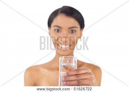 Cheerful attractive model holding glass of water posing on white background