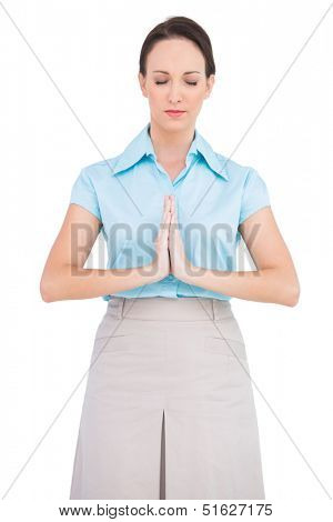 Young businesswoman praying while posing on white background