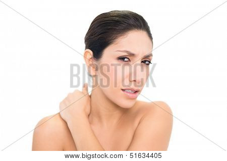 Wincing brunette touching her sore neck on white background
