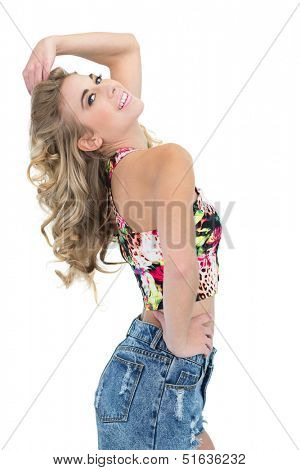 Content retro blonde model posing with a hand on the hip on white background