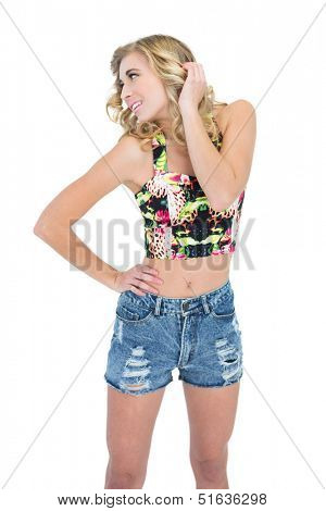 Attractive retro blonde model posing with a hand on the hip on white background