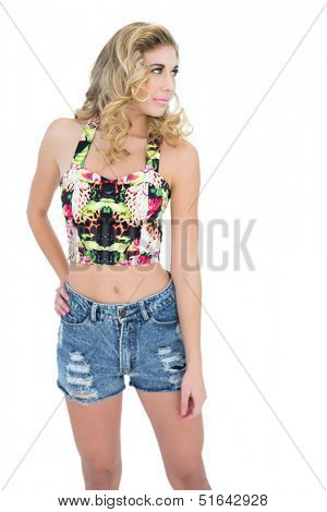 Gorgeous retro blonde model posing with a hand on the hip on white background