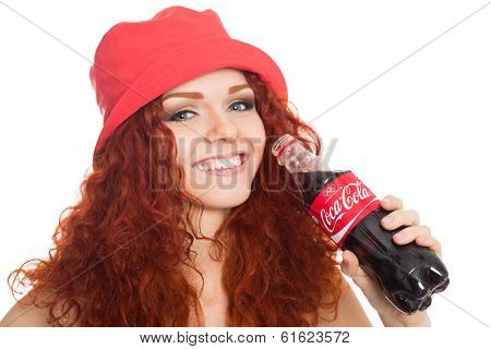 NAKHODKA, RUSSIA - MARCH 02, 2014: Beautiful girl holding a bottle of Coca-Cola. Coca-Cola is a very popular carbonated soft drink sold in stores, restaurants worldwide.