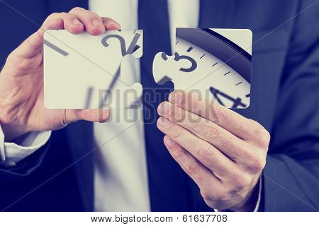 Businessman Holding Puzzle Pieces Of A Clock