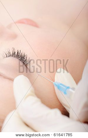Injecting a shot in a woman's face. close-up