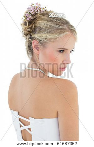 Rear view of thoughtful bride in off shoulder dress over white background
