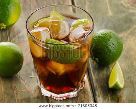 Cuba Libre Cocktail With Limes On A Wooden