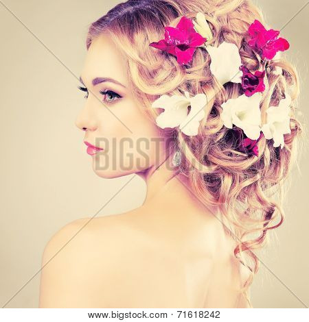 Beautiful girl, isolated on a light - grey background with varicoloured flowers in hairs, emotions, cosmetics