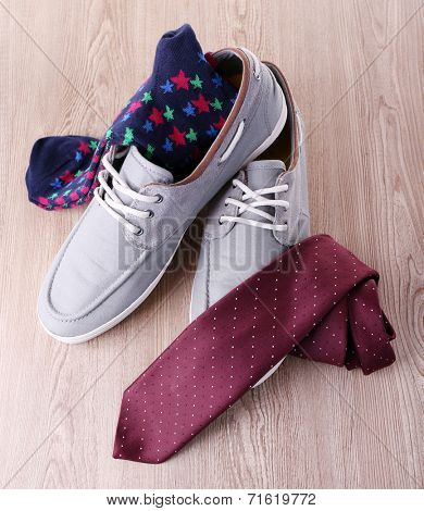 Top-Siders, pair of socks and tie on wooden background