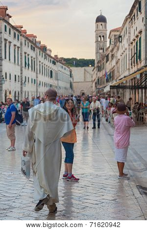 DUBROVNIK, CROATIA - MAY 26, 2014: Tourists walking on Stradun at sunset. Stradun is 300 meters long main pedestrian street in Dubrovnik.