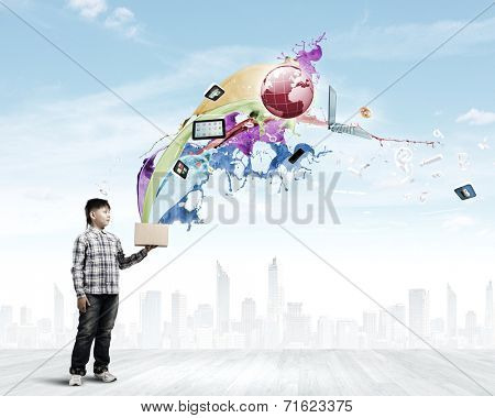 Young boy splashing colorful paint from bucket