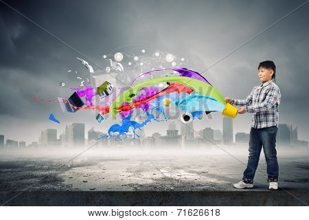 Young boy splashing colorful paint from bucket