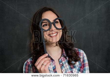 Young Woman Looking Through Opera Glasses Made Of Paper Isolated Over Gray Background