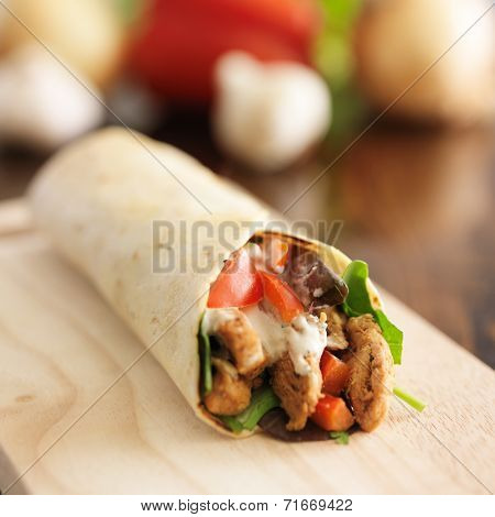 chicken wrap in tortilla with sauce and mesclun mix