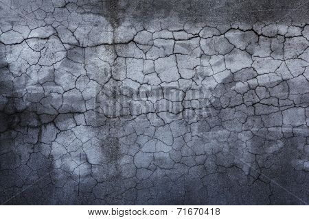 Darkish stone wall with many cracks. 