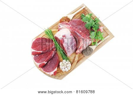 raw meat : fresh beef pork big rib and fillet with garlic and green stuff on wood isolated over white background