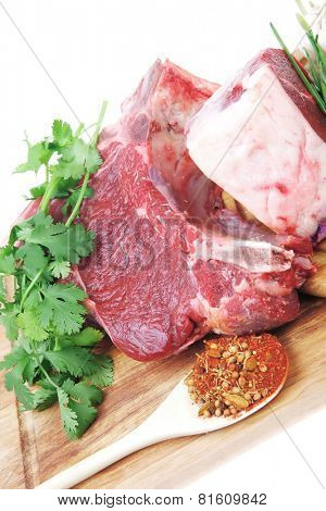 raw meat : fresh beef pork big rib and fillet with garlic and green stuff on wood isolated over white background