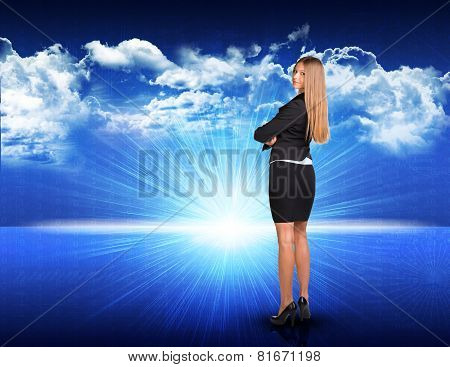 Businesswoman standing against blue landscape with rising sun