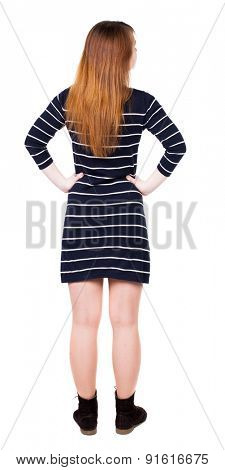 back view of standing young beautiful  woman. girl  watching. Rear view people collection. backside view person. Isolated over white background. Adding putting hands on waist stands and looks to right