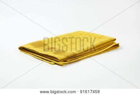 yellow and brown checkered dishtowel on white background