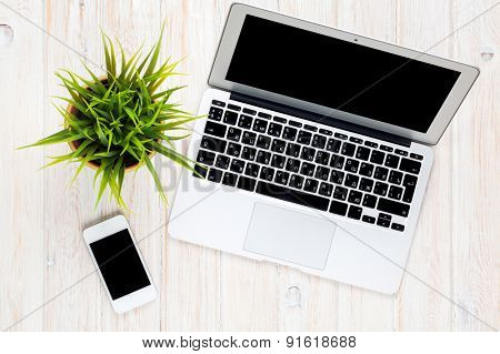 Office desk table with laptop computer and flower. Top view with copy space