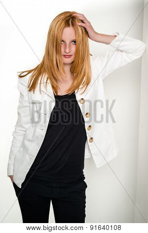 Beautiful young woman leaning against wall