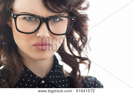 Close Up Of Frown Young Woman Over White Background. Unhappy Girl With Eyeglasses
