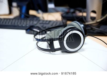 technology, electronics and audio equipment concept - close up of headphones at recording studio or radio station