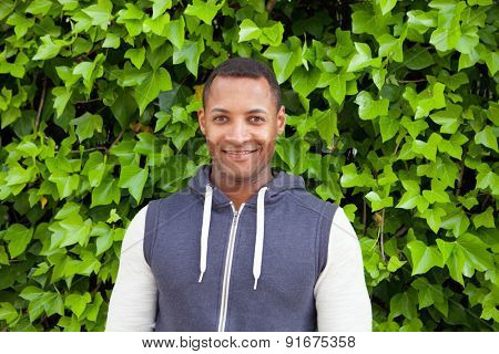 Afroamerican guy on a park with a plants of background