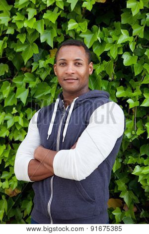 Afroamerican guy on a park with a plants of background