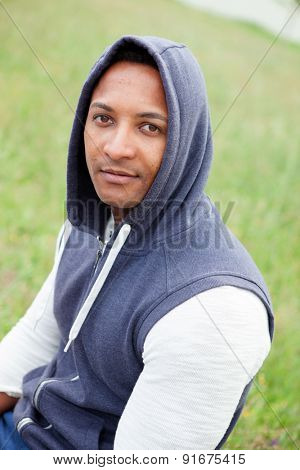 Afroamerican guy on a park with a plants of background